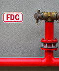 Heavy Duty 6X12 Inch Fire Department Connection FDC Sign With 3M Engineer Grade Reflective Film mounted next to red fire hydrant.