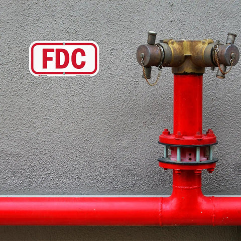 Heavy Duty 6X12 Inch Fire Department Connection FDC Sign With 3M Engineer Grade Reflective Film mounted next to red fire hydrant.