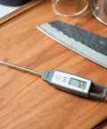 Ultra Quick Digital Kitchen Thermometer for cooking and grilling with 4.5 inch compact probe, splash resistant, on wood board.