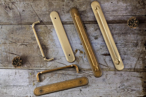 2 Pack Champagne Bronze Cabinet Pulls With Backplates, 7 1/2 Inch Center-to-Center Drawer Handles on rustic wood surface