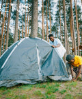 Two people setting up a tent in a forest using Fiberglass Tent Pole Replacement Kit 12 Ft Pre Assembled Black Outdoor Tent Pole.