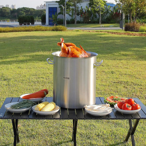 Outdoor scene of 42 Quart Stainless Steel Stock Pot With Strainer, Lid And Handles, Heavy Duty Commercial Grade with turkey on table.