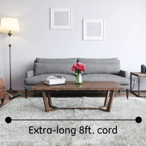 Living room scene with extra-long 8 ft. cord of Surge Protector Power Strip With Six Outlets Eight Foot Extension Cord 1300 Joules Of Surge Protection Flat Plug Twist To Close Safety Covers ETL Listed Black Perfect For Home Office And Gear.