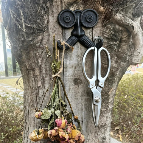 Badass Vintage Cast Iron Beard Shaped Wall Hook Kit With Heavy Duty Screws For Hanging Coats Scarves Bags And Keys While Adding Hecka Cool Antique Decor Flair To Any Entryway Or Bedroom Space with scissors and dried flowers on a tree.