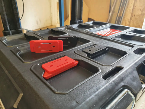 8 Pack Red Mounting Feet For Milwaukee Packout System Adapters on a toolkit surface, showing secure mounting capability.