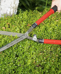 Person using Extendable Hedge Shear With 15 To 26 Inch Reach, 8.5 Inch Forged High Carbon Steel Blades on green hedge