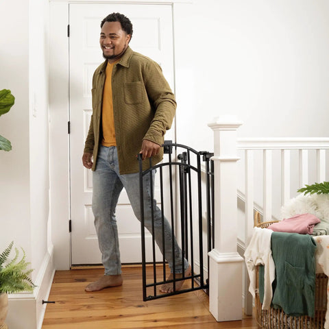 Man opening Extra Tall Walk Through Baby Gate For Doorways And Stairs Fits Openings From 28.5 To 48 Inches 36 Inch Tall Black Metal Safety Gate No Drill Pressure Mount Ideal For Babies And Pets At Home