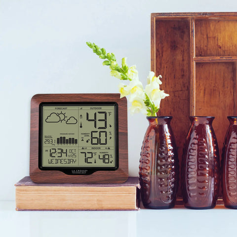 Backlit Wireless Forecast Weather Station With Pressure And Temp Trends Indoor Outdoor Temp Humidity 24 Hour Pressure History Temperature Alerts And Continuous Display on a wooden shelf with decor