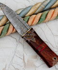 Damascus Steel Fixed Blade Camping Knife With Walnut Wood Handle Brass Bolster And Leather Sheath Included Hand Forged High Carbon Outdoors Gear Built Tough For Survival on marble surface