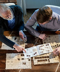 Two people assembling Steampunk 3D Puzzle Clock Kit For Adults With 378 Pieces Including 43 Spare Parts, using colorful instructions.
