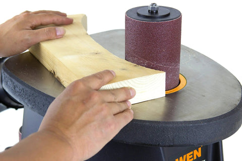 Using Powerful 3.5 Amp Oscillating Spindle Sander With 58 OPM At 2000 RPM to shape wood on work table.