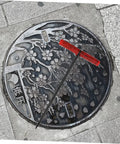 Heavy Duty Manhole Cover Lifter Hook Rock Solid Steel Build With Secure Comfort Handle and Slick T Shape Design on a manhole.