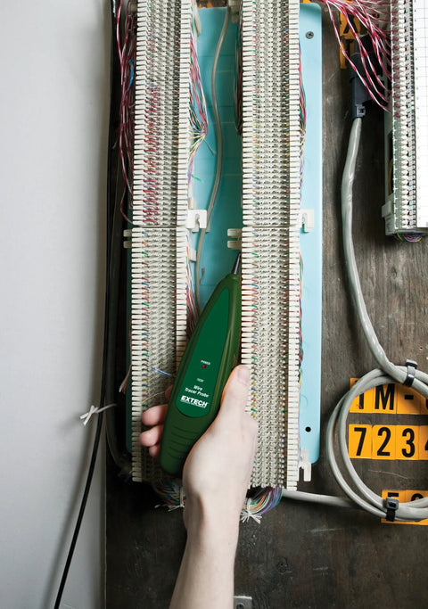 Hand using Wire Tracer Kit With Tone Generator For Cable Locator, Non Contact Probe, on cable panel