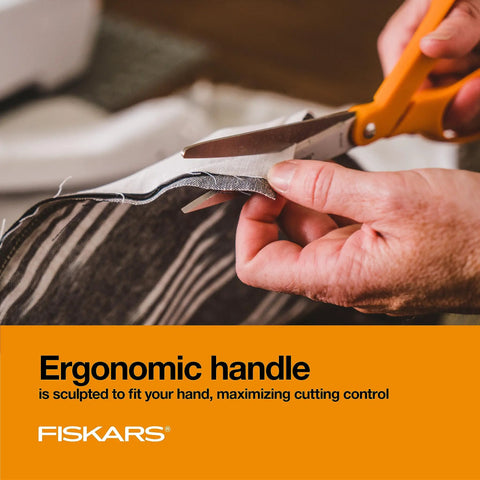 Close-up of orange handle stainless steel scissors cutting fabric, ergonomic design for all purpose cutting tasks.
