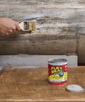 Liquid Rubber Sealant Coating applied with a brush for waterproof flexible protection, 16 oz can on table, sealing wood surface