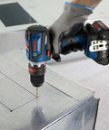 Compact 18V Cordless Drill Driver With Brushless Motor And Rugged Locking Chuck Supporting 5In1 Flexiclick Quick Swap System Paired With A Badass 4Ah Battery Pack drilling into metal surface.