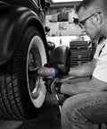 Person using half inch pneumatic impact wrench with 750 ft lbs torque three speed regulator for easy lug nut removal on car wheel