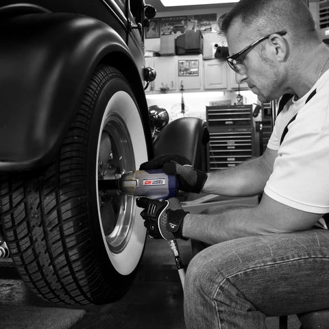 Person using half inch pneumatic impact wrench with 750 ft lbs torque three speed regulator for easy lug nut removal on car wheel