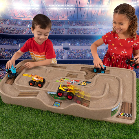 Children playing with the On The Go Kid Friendly Race Track Table With 2-Sided Play Surface For Cars And Trains in a stadium-like setting