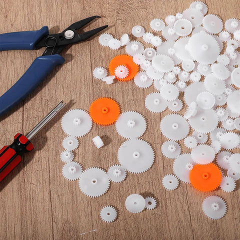 200Pcs White Plastic Gears Module 0.5 For DC Motors RC Cars DIY Models Robots Replacement Kit on wooden surface with tools