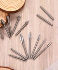 Wood Carving And Engraving Drill Bit Set 15 Piece Kit with engraving bits and HSS carbide rotary burrs on wooden surface.
