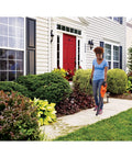 Woman using Cordless Leaf Blower With Battery And Charger, 20V Max, 130 MPH Air Speed, Ultralight 3.7 Lb Design on sidewalk