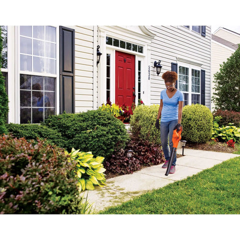 Woman using Cordless Leaf Blower With Battery And Charger, 20V Max, 130 MPH Air Speed, Ultralight 3.7 Lb Design on sidewalk