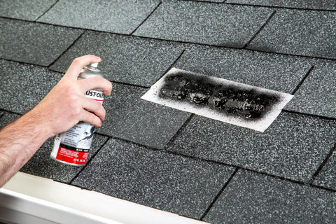 Hand using spray can of Triple Thick Roof Patch And Sealer Spray 13 Oz Black on shingle roof for quick heavy duty roof repairs.