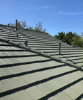 Heavy Duty Tile Roof Glaze And Clear Shielding Sealant With Urethane Reinforced Strength For Tough As Nails Weather Barrier And A Sleek Satin Finish That Gonna Save Your Tiles From Failing In A Practical Five Gallon Size applied on a sloped green tiled roof.