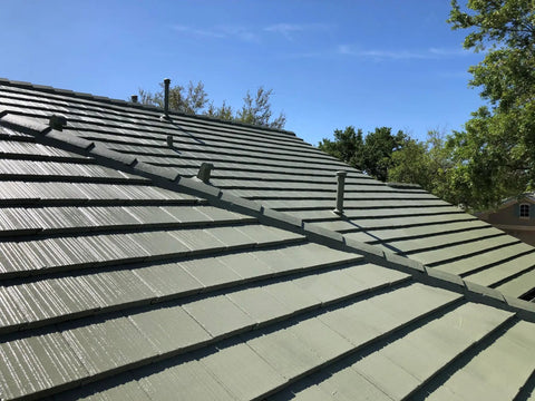 Heavy Duty Tile Roof Glaze And Clear Shielding Sealant With Urethane Reinforced Strength For Tough As Nails Weather Barrier And A Sleek Satin Finish That Gonna Save Your Tiles From Failing In A Practical Five Gallon Size applied on a sloped green tiled roof.
