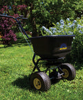 Spyker P20 5010 50 Pound Capacity Broadcast Spreader on grass with powder coated frame and adjustable handle