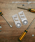 Four Pack Stainless Steel Sliding Door Pulley Wheels With Internal Ball Bearings For A Rock Solid Build And Runs Like A Dream Rail Glide positioned with tools on a wooden surface.