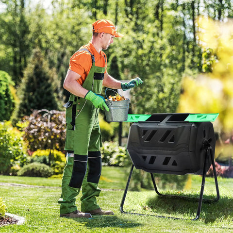 Man using Massive Outdoor Dual Bin Composter Tumbling 43 Gallon Rotating Compost Bin With Two Sliding Doors And Aeration System in garden