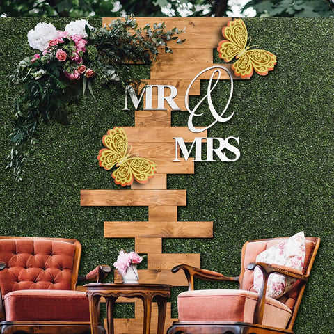 12 Pack 10 By 10 Inch Boxwood Panels Artificial Grass Wall Backdrop with wooden decor, flowers, and Mr & Mrs sign