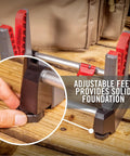 Close-up of Speed Stand Collapsible Gun Vise For Cleaning And Maintenance Adjustable 10 To 16 Inch Stand's adjustable feet on wood.