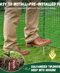 Man installing Heavy Duty 3x50 Ft Temporary Fence Kit For Backyard Pets And Poultry with fiberglass post and ground peg.