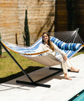 12 Ft Outdoor Hammock With Stand For Two, Freestanding Yard Lounger With Curved Spreader Bars in Blue Stripes by a pool