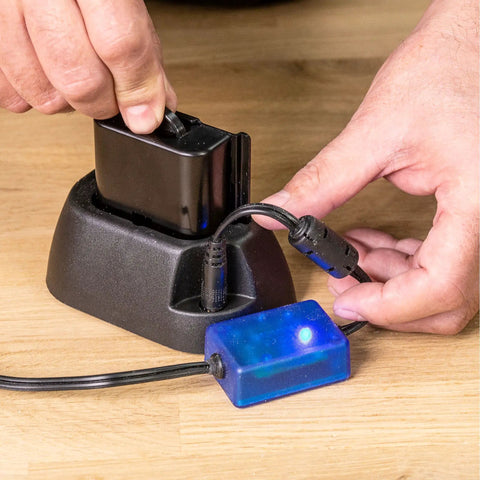 Person using Airshield Pro Remote Battery Charging Cradle For AIR/P/7 Keeps Your Pro Charged On The Go With A Spare Battery