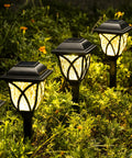 6 Pack Solar Pathway Lights Outdoor LED Garden Lights Waterproof Landscape Lights illuminating garden at dusk.