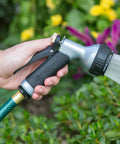 Person using Small Metal Garden Hose Nozzle With Seven Spray Patterns, Easy Grip Handle For Smaller Hands, Durable Metal Construction.