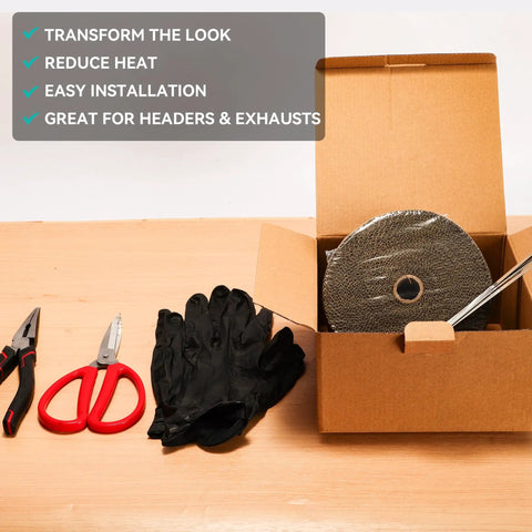 2 Inch By 16 Foot Titanium Fiberglass Exhaust Heat Wrap Roll With Heat Shield Tape Kit Includes 10 Stainless Zip Ties Gloves Red Measuring Tool And Setup Manual For Motorcycle Car And Truck For All Rides. Open box with contents displayed on a wooden table, including a roll of heat wrap, red tools, gloves, and zip ties.