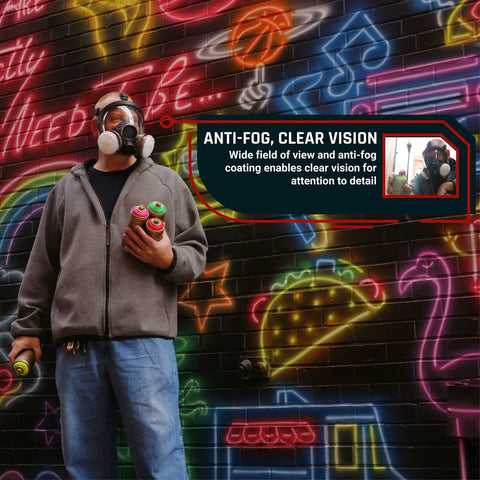 Man wearing Smoke Black Full Face Respirator With Dual Activated Charcoal Filtration For Organic Vapor And Particulate Protection Anti Fog Eye Shield Heavy Duty Mask Built For Rugged Outdoor Gigs And Industrial Settings near neon wall.
