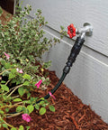 Drip Irrigation Faucet Connection Kit for 1/2 Inch Tubing with Easy Fit attached to outdoor faucet near garden