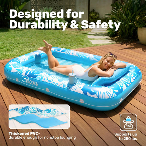 Adult relaxing on Inflatable Tanning Pool Lounger Float 70 Inch with Pillow, blue design, in backyard setting for sunbathing and pool party.