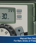 Close-up of Four Station Outdoor Sprinkler Timer With Swing Panel showing 6:30 AM time display and manual rain delay buttons.