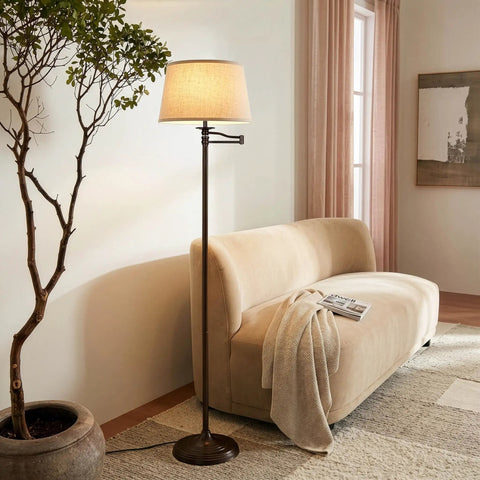 Caden LED Floor Lamp With Swing Arm Tall Bronze Standing Light beside a beige sofa in a living room setting