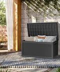 320 Gallon Lockable Resin Deck Box Waterproof And UV Resistant Outdoor Storage Box For Cushions Garden Tools And Pool Accessories Beefy Heavy Duty Weatherproof Black on patio with lid open showing stored cushions.