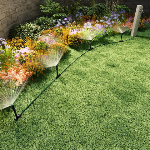 Flexible Sprinkler System for Lawn and Garden Beds DIY Irrigation Kit with Adjustable Sprinkler Heads Above Ground Watering Solution for Lawn Flowers and Vegetables 50ft Garden Hose Included spraying water on flowers and grass.
