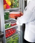 Chef placing Clear Polycarbonate Food Storage Tote 16.5 Gallon in refrigerator, BPA Free, for restaurant kitchen use.