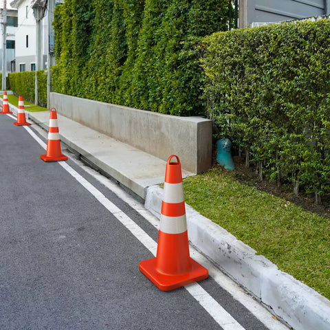 Row of heavy duty 28 inch traffic safety cones set of 6 with handles high visibility orange with reflective collars on a parking lot.